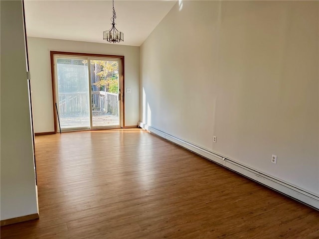 interior space with an inviting chandelier, a baseboard radiator, vaulted ceiling, and light hardwood / wood-style floors