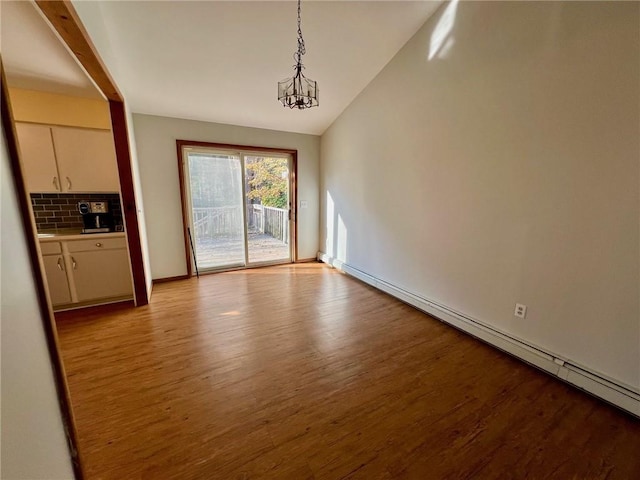 unfurnished dining area with baseboard heating, light hardwood / wood-style flooring, vaulted ceiling, and a notable chandelier