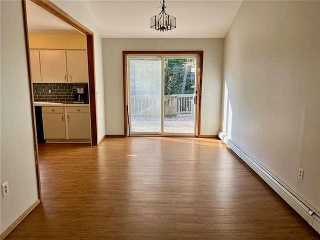 doorway to outside featuring a notable chandelier, light hardwood / wood-style floors, and a baseboard radiator