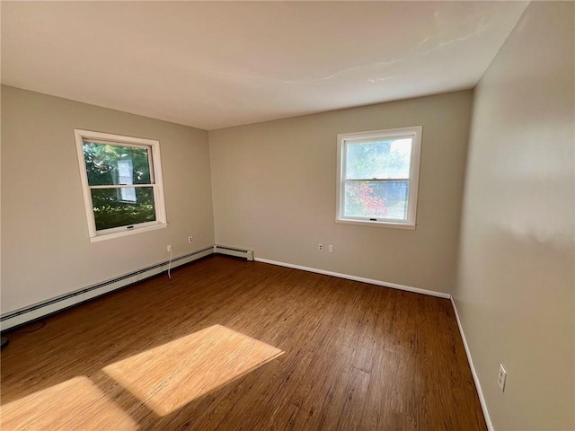 empty room with hardwood / wood-style flooring and a baseboard radiator