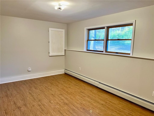 spare room featuring light wood-type flooring and a baseboard heating unit