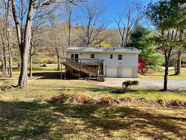 back of property with a garage, a deck, and a yard