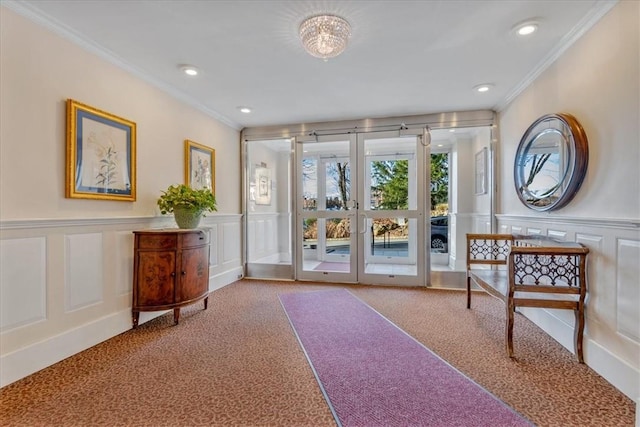 doorway to outside with light carpet, french doors, a notable chandelier, and ornamental molding