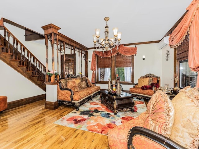 living room with wood-type flooring, crown molding, an AC wall unit, and a chandelier