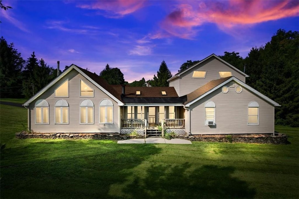 back house at dusk featuring a yard