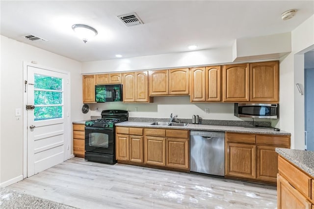 kitchen featuring sink, light hardwood / wood-style floors, and black appliances