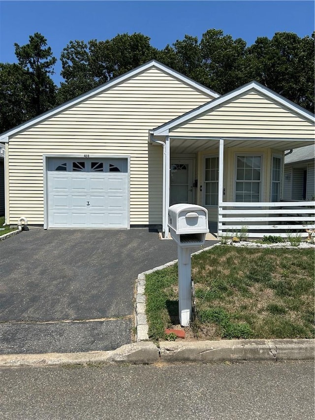 ranch-style home featuring covered porch and a garage