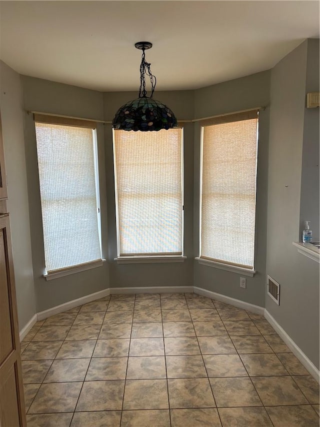 unfurnished dining area with tile patterned floors and plenty of natural light