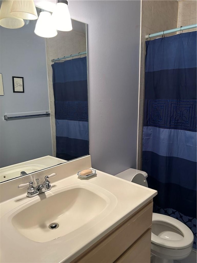 bathroom with a shower with shower curtain, vanity, and toilet