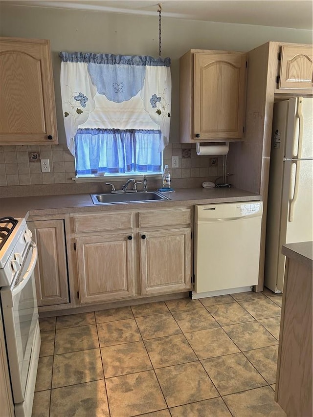 kitchen with decorative backsplash, white appliances, sink, and light brown cabinetry