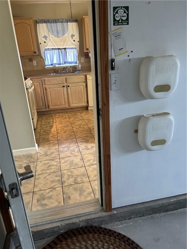 interior space with sink, white electric range oven, tasteful backsplash, light brown cabinetry, and light tile patterned floors