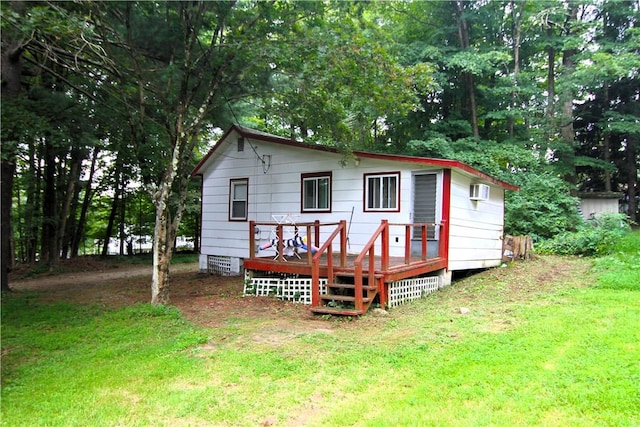 back of house with a lawn and a deck