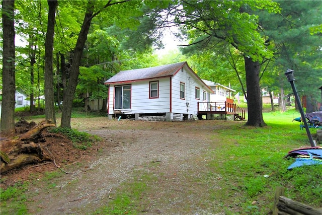 view of home's exterior featuring a deck and a yard