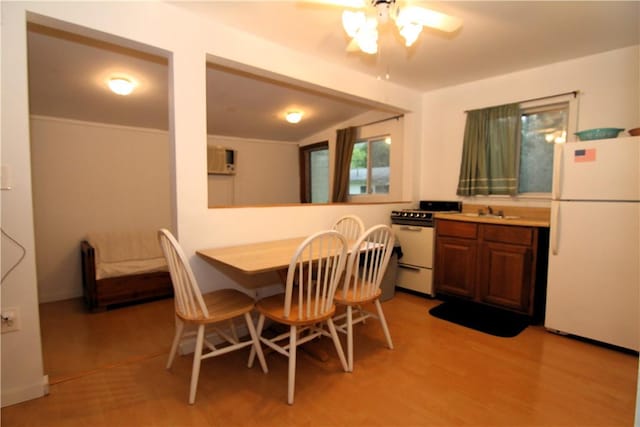 dining room featuring ceiling fan, light wood-type flooring, and vaulted ceiling