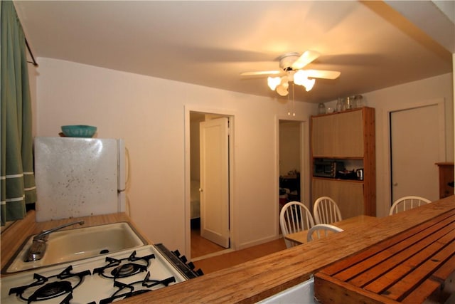 kitchen featuring ceiling fan, white appliances, and sink