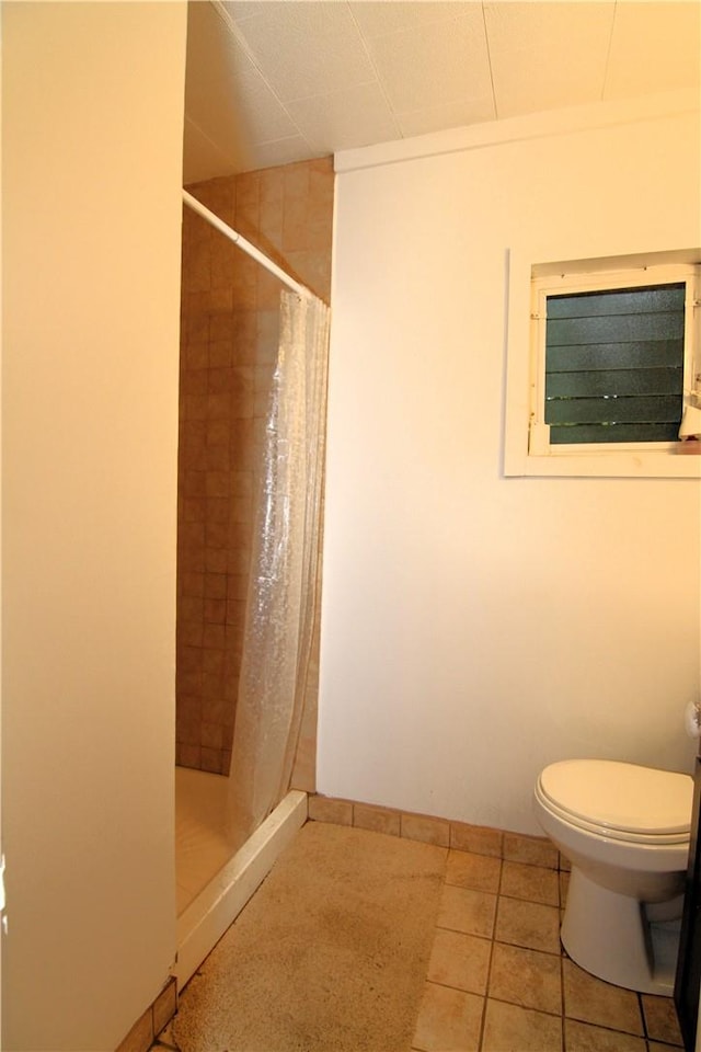 bathroom with tile patterned floors, toilet, and a shower with shower curtain