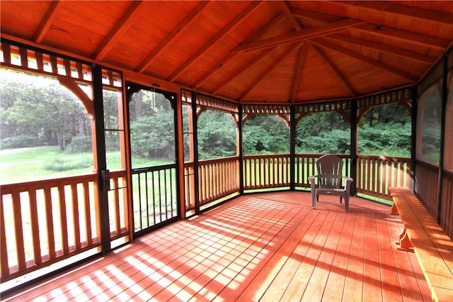 unfurnished sunroom with vaulted ceiling with beams and wooden ceiling