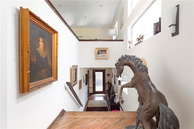 hall with plenty of natural light and hardwood / wood-style floors