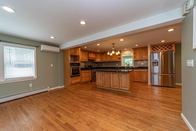 kitchen featuring appliances with stainless steel finishes, a wall unit AC, light hardwood / wood-style floors, a kitchen island, and hanging light fixtures