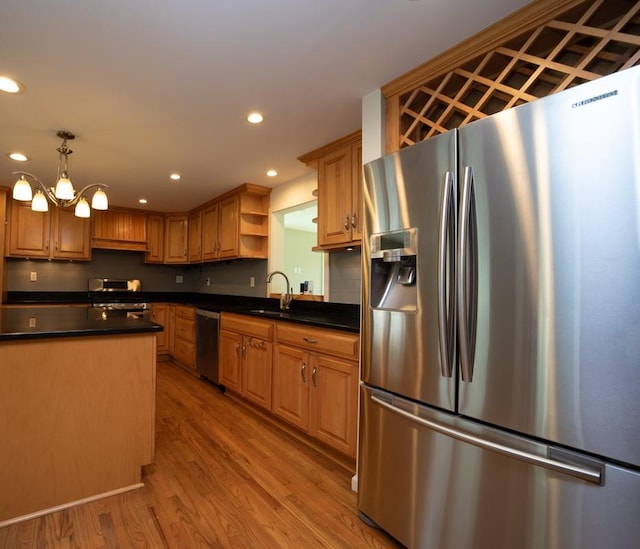 kitchen featuring an inviting chandelier, sink, hanging light fixtures, light hardwood / wood-style flooring, and stainless steel appliances