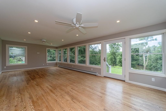 unfurnished living room featuring light hardwood / wood-style floors, ceiling fan, and a baseboard heating unit