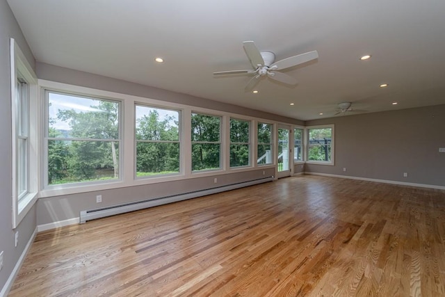 interior space with light wood-type flooring, baseboard heating, and ceiling fan