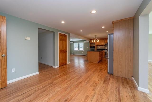 kitchen featuring pendant lighting, a center island, light wood-type flooring, and appliances with stainless steel finishes