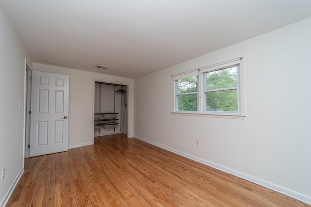 unfurnished bedroom with a closet and light wood-type flooring