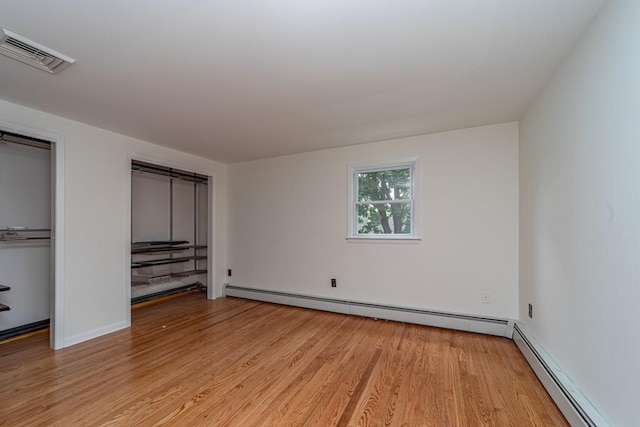 unfurnished bedroom featuring light hardwood / wood-style floors and a baseboard radiator