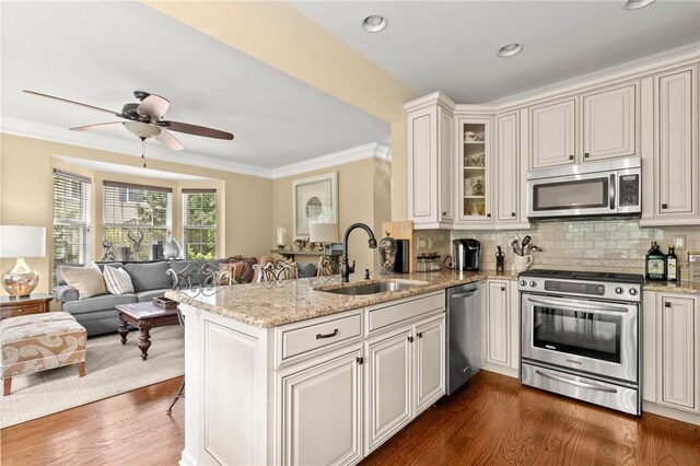 kitchen with dark hardwood / wood-style flooring, kitchen peninsula, sink, and appliances with stainless steel finishes