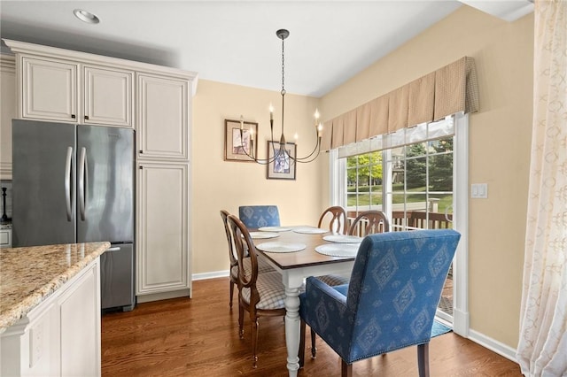 dining area featuring dark hardwood / wood-style floors and an inviting chandelier