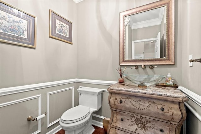 bathroom featuring vanity, toilet, and ornamental molding