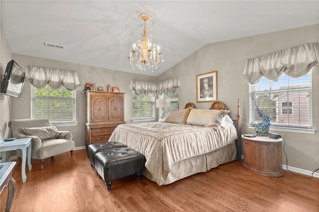 bedroom featuring wood-type flooring, multiple windows, and a notable chandelier