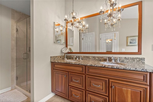 bathroom with vanity, a shower with shower door, and a chandelier