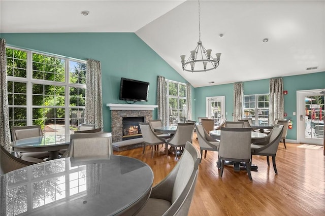 dining space with a fireplace, plenty of natural light, and light hardwood / wood-style floors