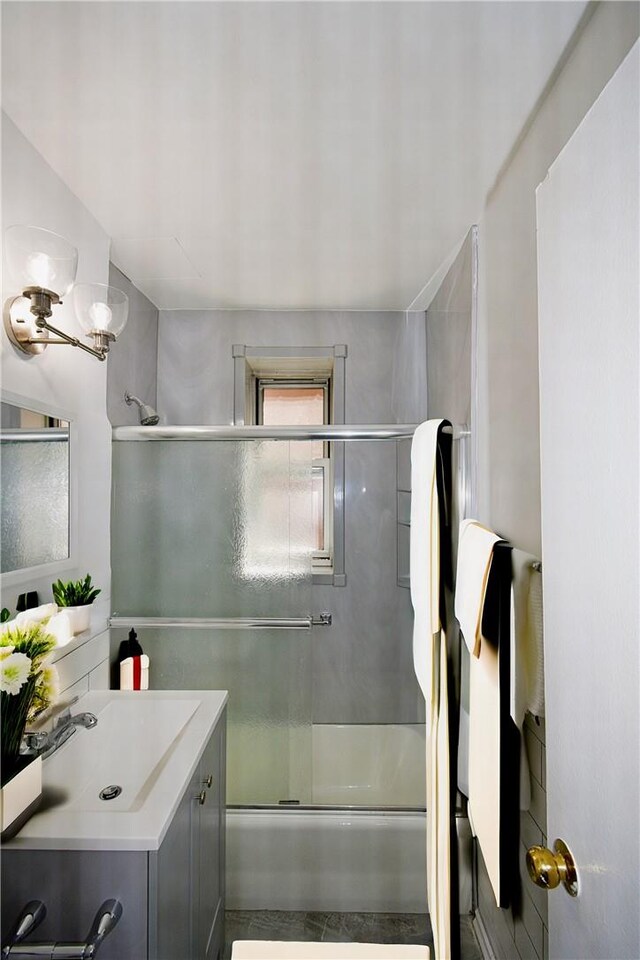 bathroom with vanity and bath / shower combo with glass door