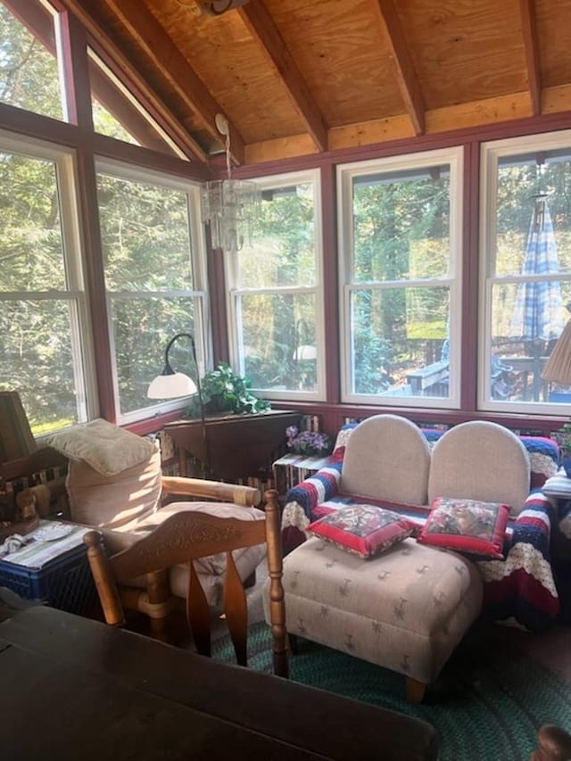 sunroom featuring vaulted ceiling with beams and a wealth of natural light