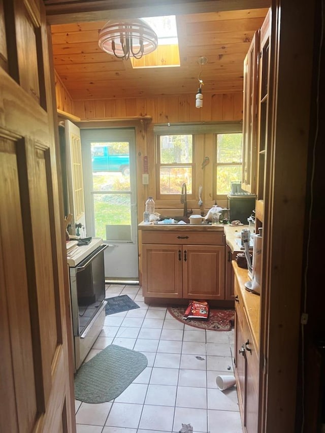 kitchen with light tile patterned floors, range with electric stovetop, wooden walls, and wood ceiling