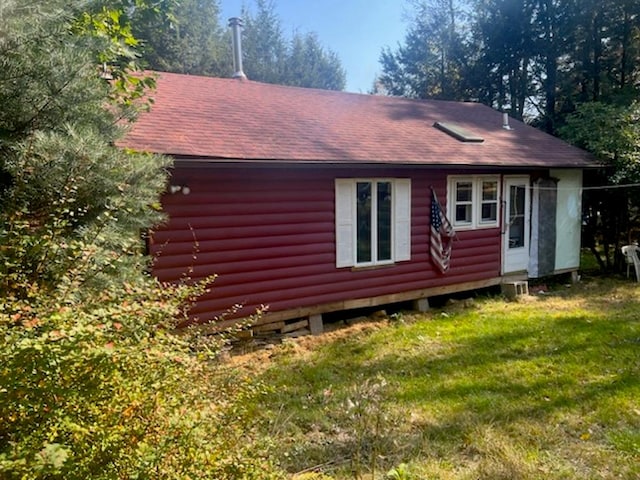 rear view of house featuring a lawn