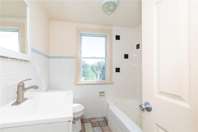 bathroom with a washtub, toilet, tile walls, and sink