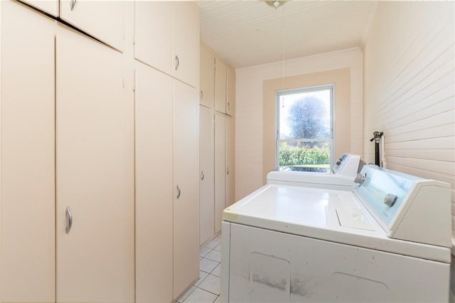 washroom with cabinets, light tile patterned floors, and washer and clothes dryer