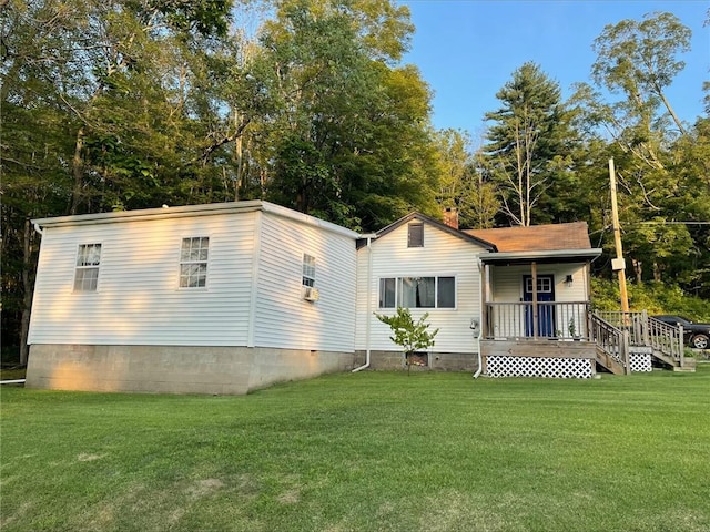 rear view of property with a porch and a yard