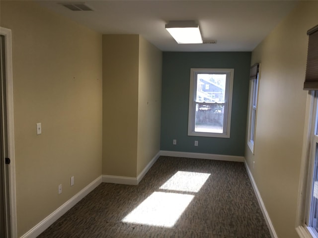 empty room featuring dark colored carpet