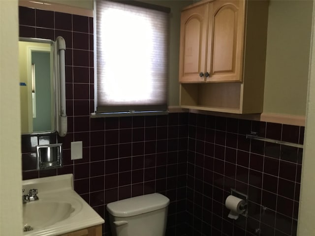 bathroom with vanity, tile walls, and toilet