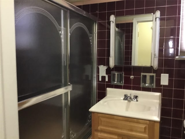 bathroom with decorative backsplash, vanity, and tile walls