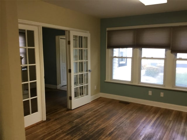 empty room featuring dark wood-type flooring and french doors