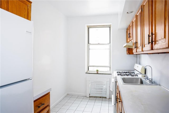 kitchen with plenty of natural light, white appliances, and light tile patterned floors