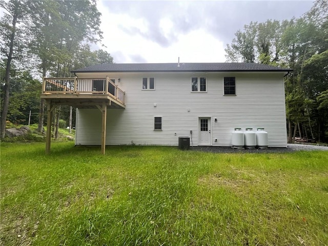 back of property with a lawn, a wooden deck, and cooling unit