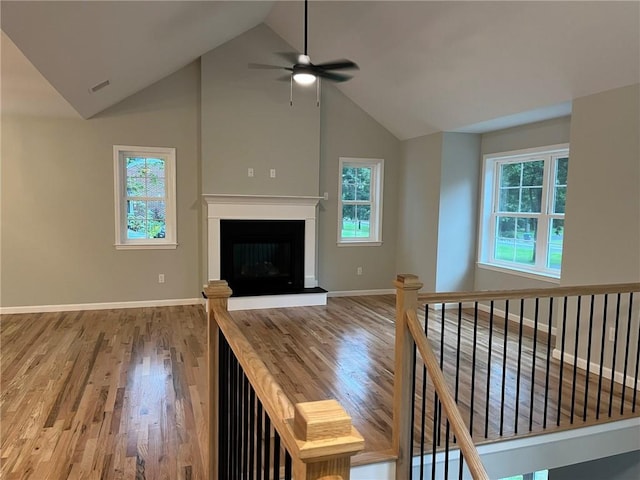 unfurnished living room with ceiling fan, hardwood / wood-style floors, and high vaulted ceiling