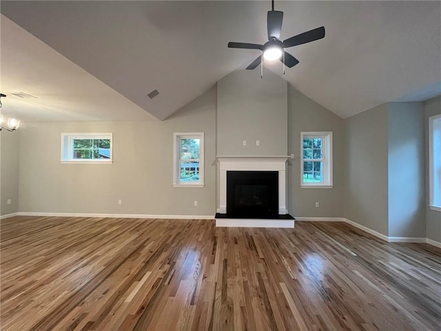 unfurnished living room featuring hardwood / wood-style floors, ceiling fan with notable chandelier, and plenty of natural light